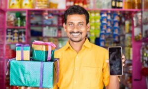 Indian kirana store owner using smartphone for traditional business digitalization